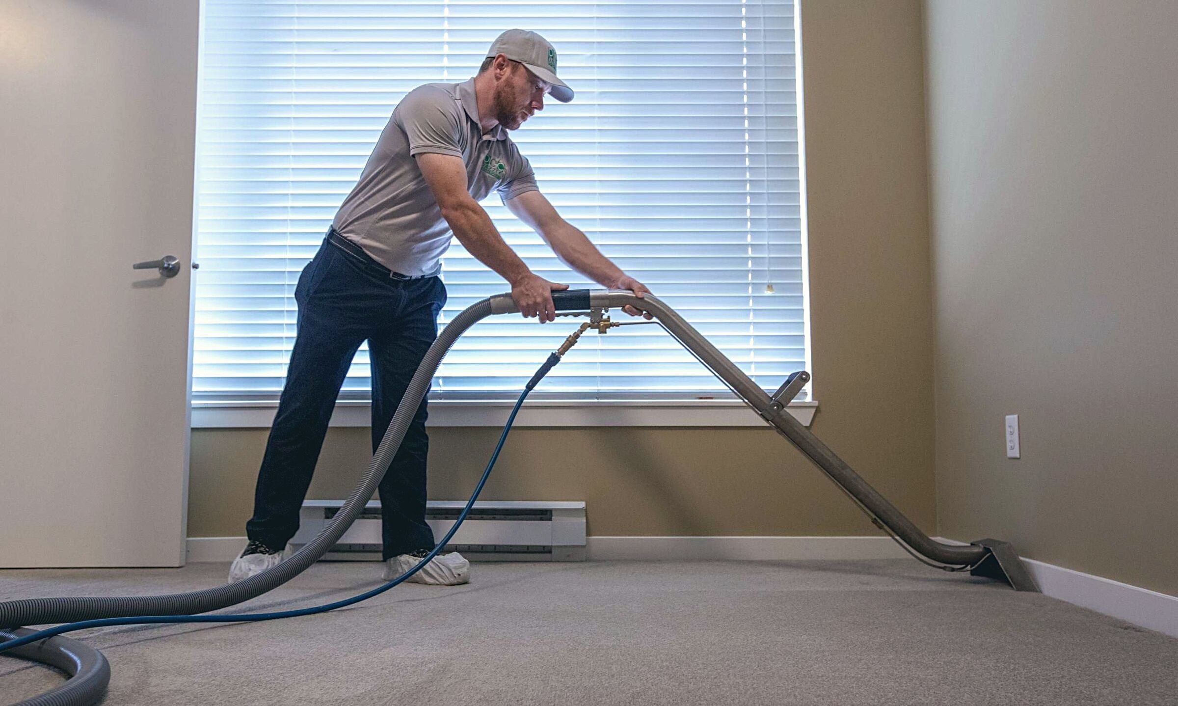 Dazzle technician steam cleaning a bedroom carpet with a truck-mounted wand